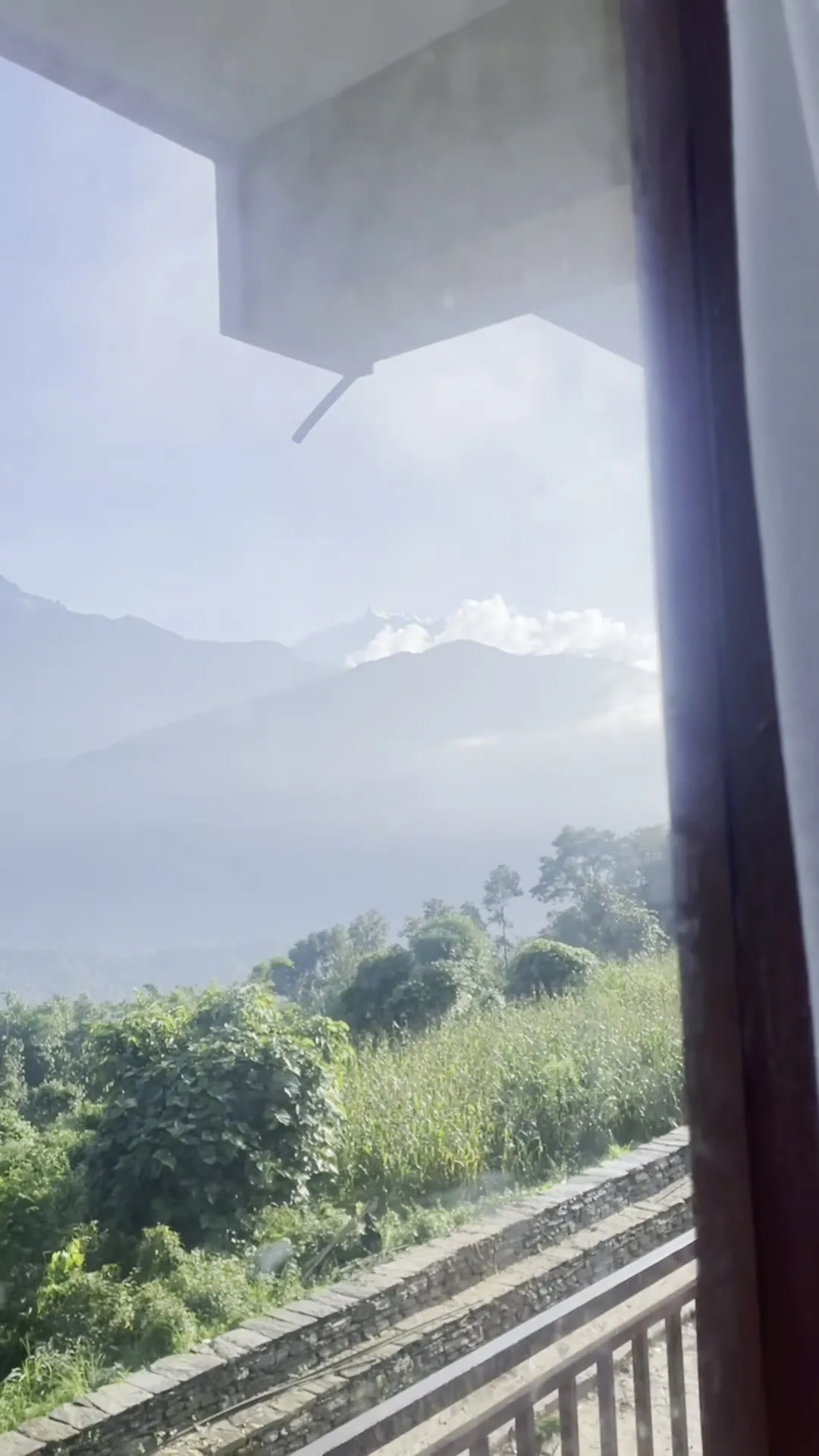 The mountains seen from beneath the eave of the resort terrace, with mist in the valley.